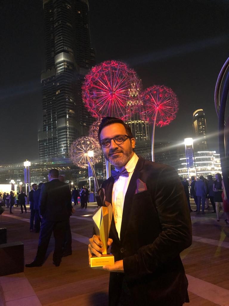 Bimal Lulla holding the Emaar award in Downtown Dubai, Burj Khalifa behind